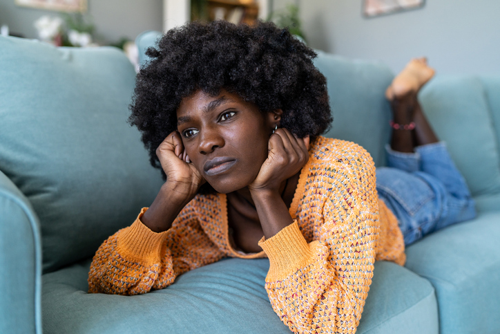Sad woman lying on a sofa