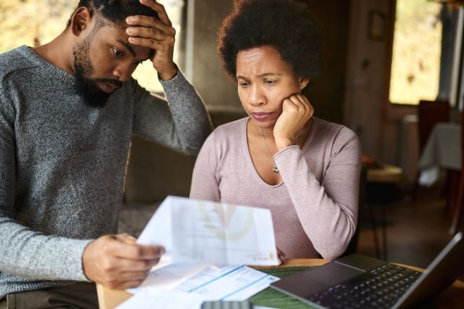 Worried black couple having problems with their financial bills at home.