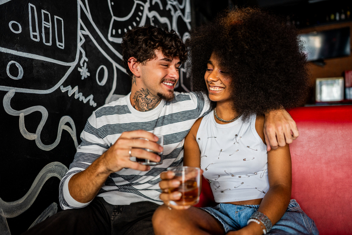 Young couple talking and drinking soda on restaurant