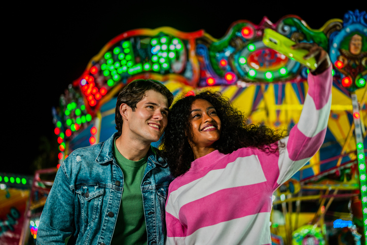 Young couple taking a selfie at amusement park