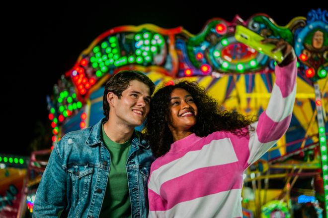 Young couple taking a selfie at amusement park