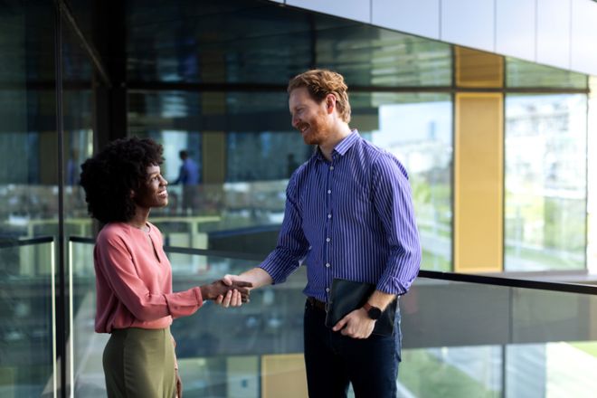 Businesswoman and businessman having discussion in front of the office