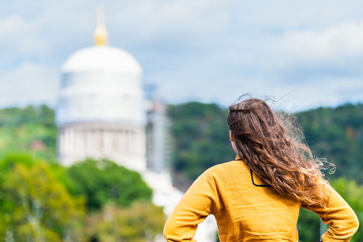 Charleston, West Virginia capital city with back of woman looking at scaffold construction on state capitol dome