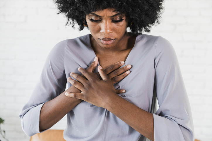Woman holding chest in pain, emotional distress, mental health