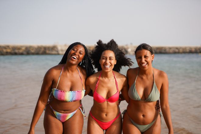 Group of happy multiracial girls walking on the beach during summer vacation - Young people, diversity and travel holiday concept