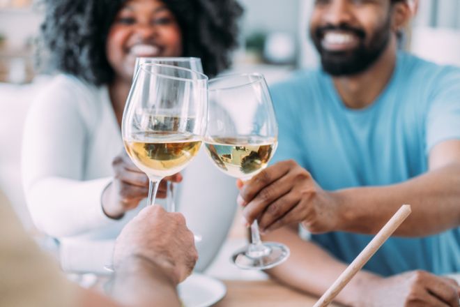 Friends toasting with white wine on a party at home.