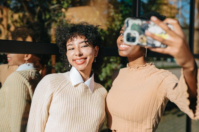 Smiling young women taking selfie outdoors