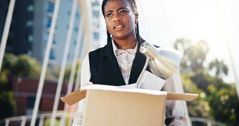 Frustrated, black woman or fired with box in city for job loss, retrenchment or work termination. Female person, unemployment and carrying equipment for layoff or economic recession in an urban town