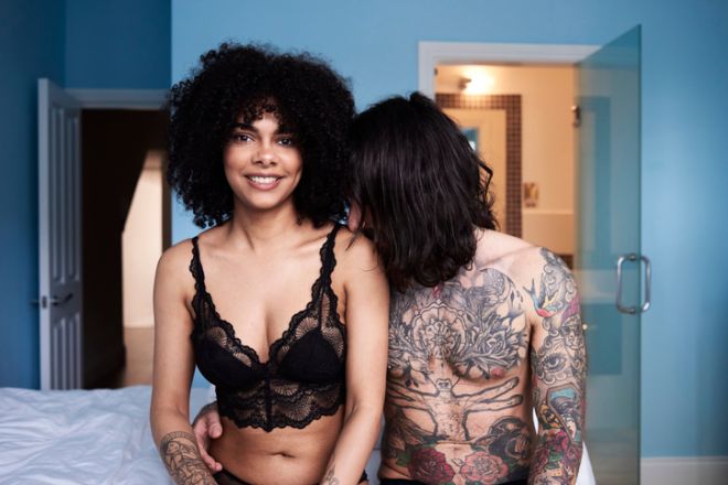 Portrait of smiling young couple sitting on bed