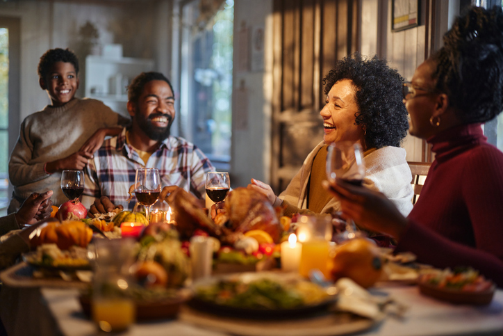 Happy black multi-generation family enjoying in lunch on Thanksgiving.