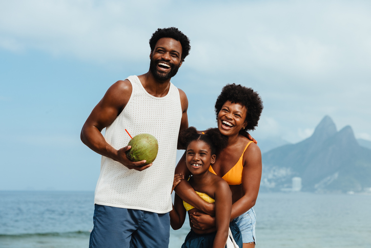 Joyful Brazilian family enjoying holiday by the Rio beachside