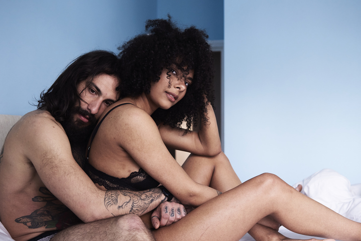 Affectionate young couple hugging in bed